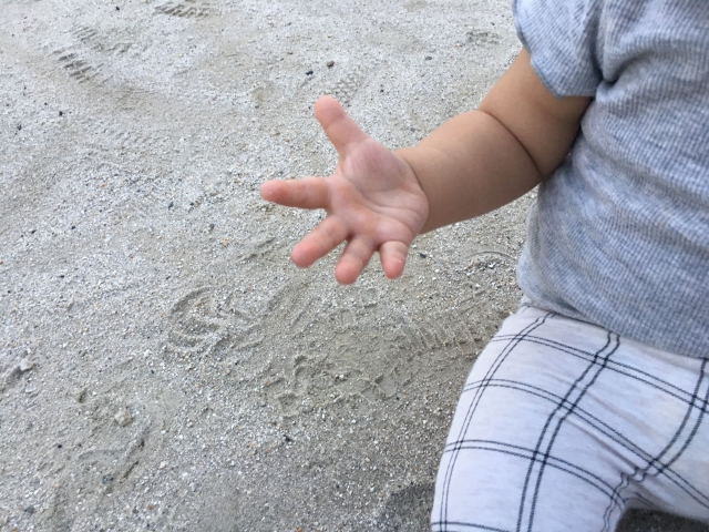 砂場で遊ぶ子供の手